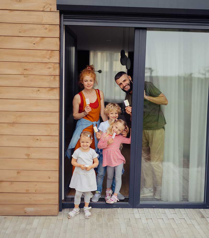 Familie vor ihrem Eigenheim, betreut vom Rieth Eigentümer-Service